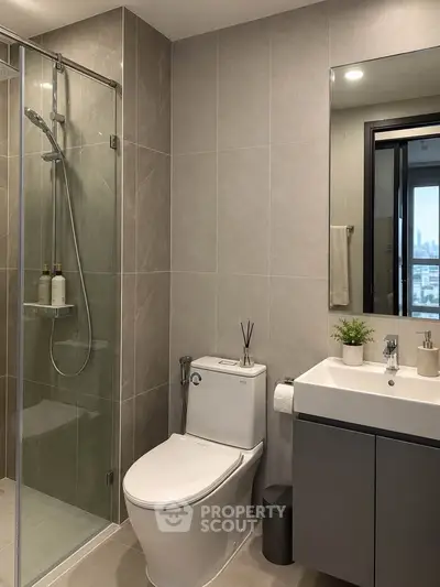 Modern bathroom with sleek fixtures and glass shower enclosure in a contemporary apartment.