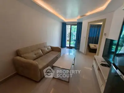 Modern living room with sleek sofa and large TV, overlooking lush garden view.