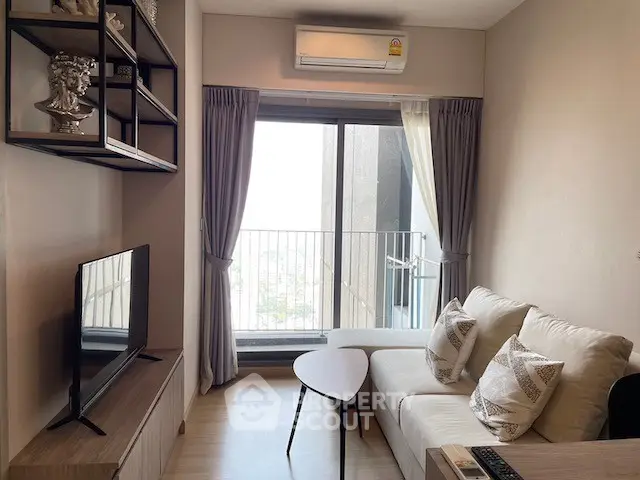 Modern living room with balcony view, cozy sofa, and stylish decor in a high-rise apartment.