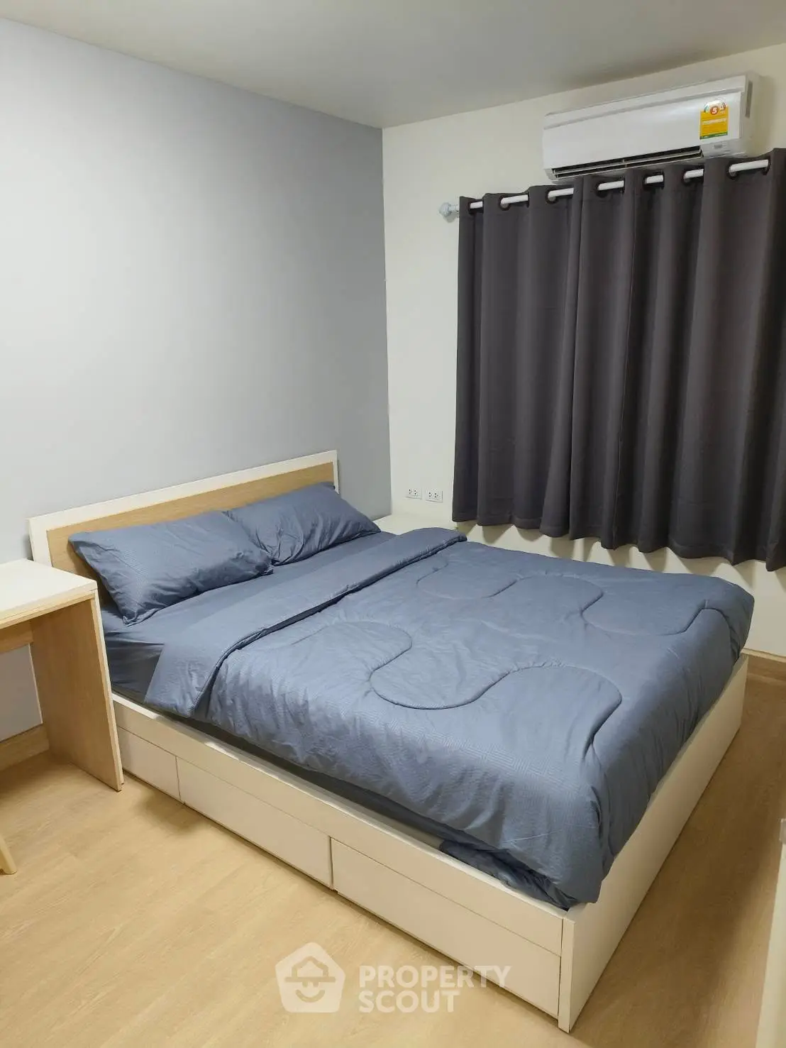 Cozy bedroom with modern furnishings and air conditioning, perfect for comfortable living.