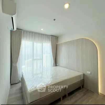 Modern bedroom with large window and elegant curtains, featuring a minimalist design and ample natural light.