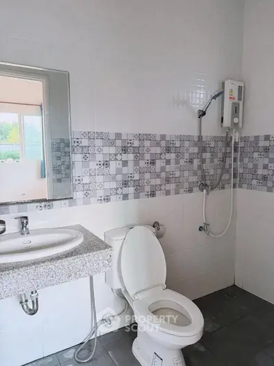 Modern bathroom with shower and tiled walls in a real estate property.