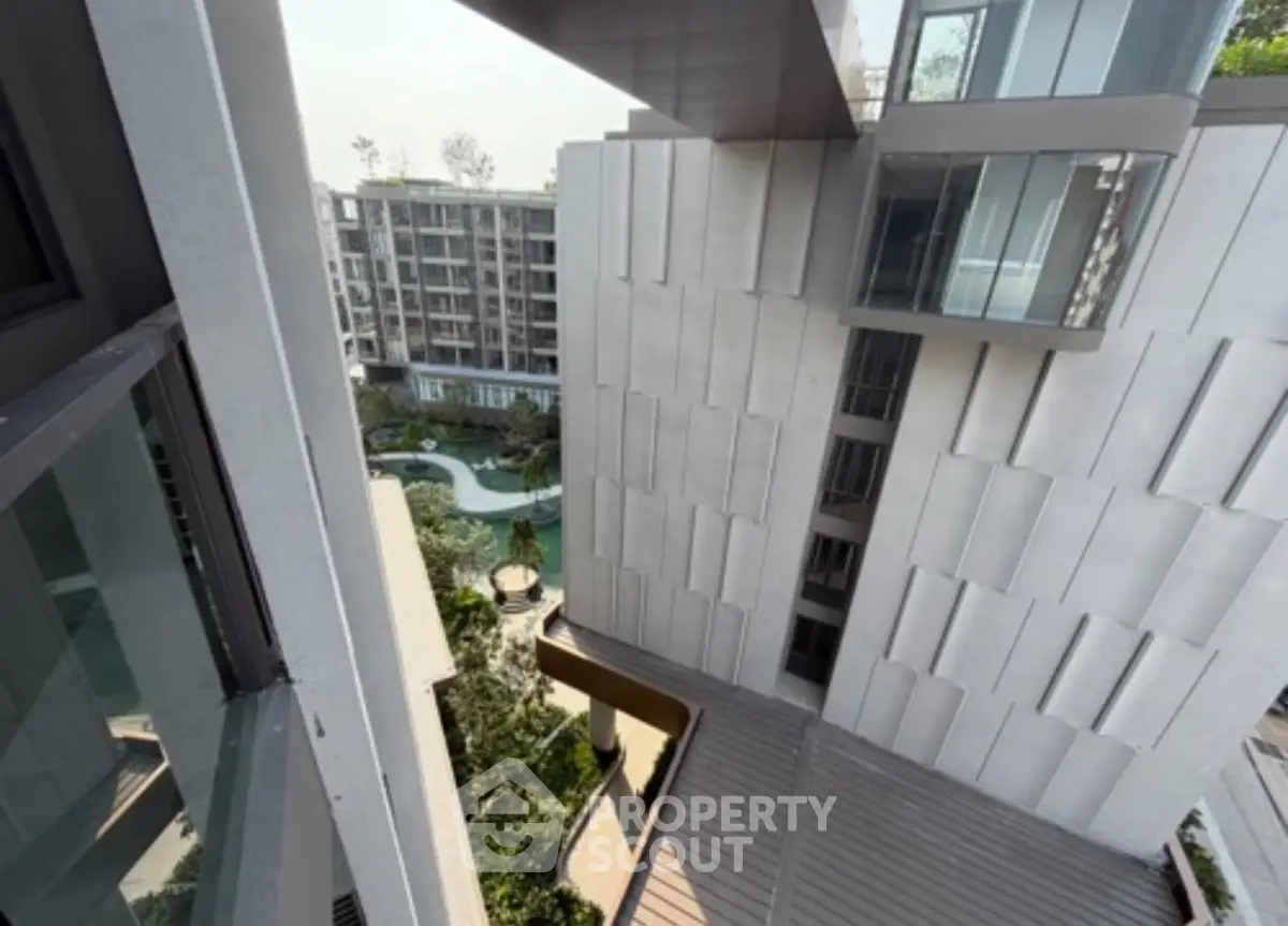Modern apartment building with unique architectural design and lush garden view.