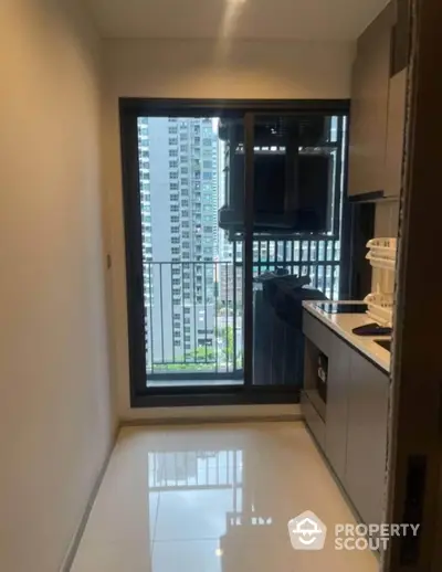 Modern compact kitchen with city view and sleek cabinetry