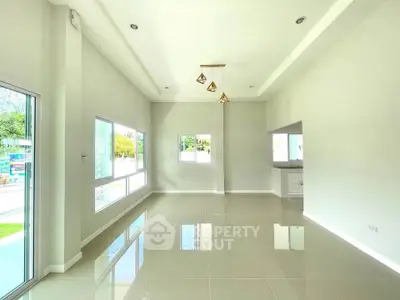 Spacious modern living room with large windows and elegant lighting