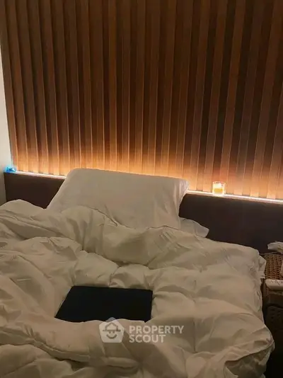 Cozy bedroom with soft lighting and plush bedding, perfect for relaxation.