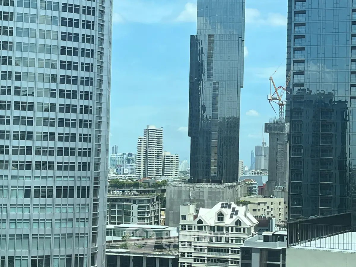 Stunning cityscape view from high-rise building with modern architecture and clear blue sky.