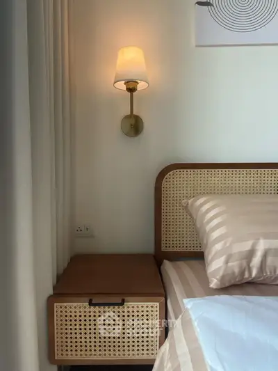 Cozy bedroom with stylish rattan headboard and elegant wall sconce lighting.