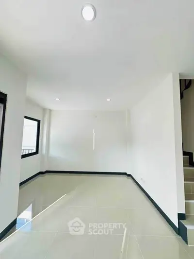 Spacious and bright living room with modern tile flooring and ample natural light.