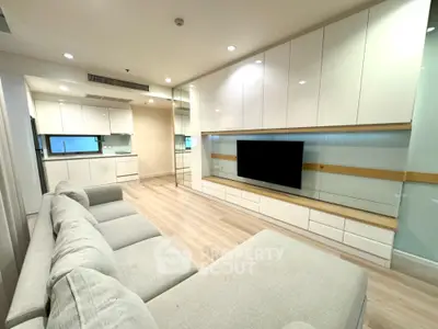 Modern living room with sleek white cabinetry and large sectional sofa