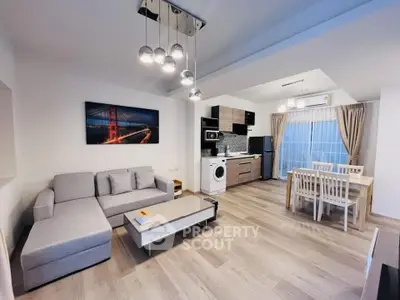 Modern open-plan living room and kitchen with stylish decor and natural light.