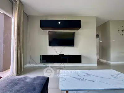 Modern living room with wall-mounted TV and sleek furniture