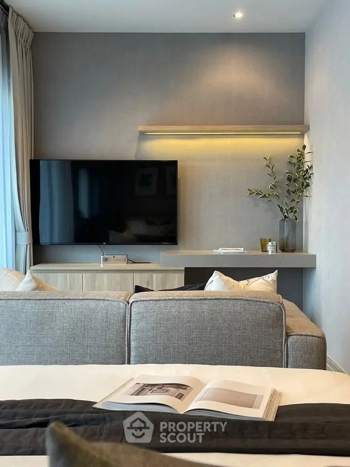 Modern living room with sleek TV setup and cozy sofa, perfect for relaxation and entertainment.