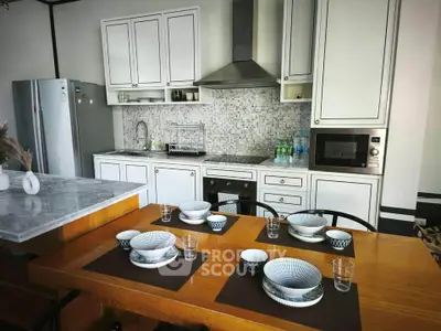 Modern kitchen with stylish dining setup and sleek appliances