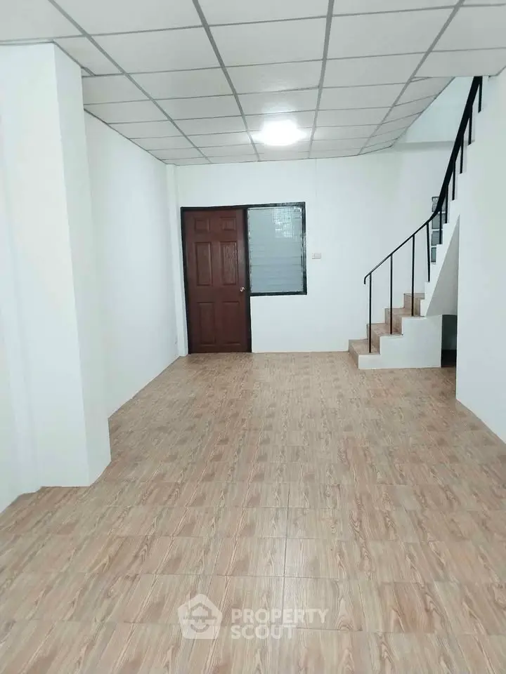 Spacious interior with wooden flooring and staircase, ideal for modern living.