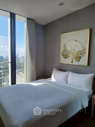 Modern bedroom with city view, featuring elegant decor and natural light.