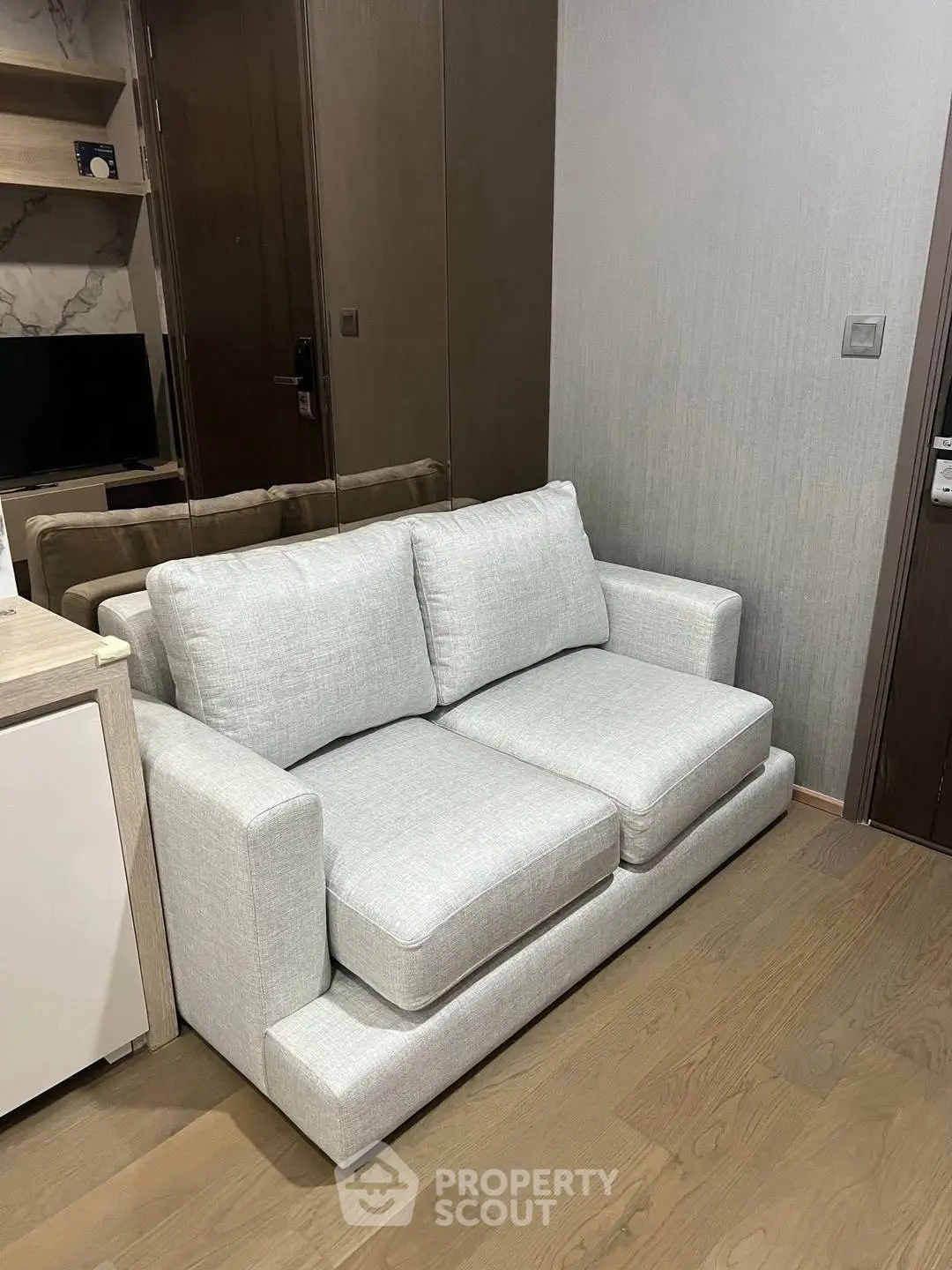 Modern living room with stylish gray sofa and wooden flooring