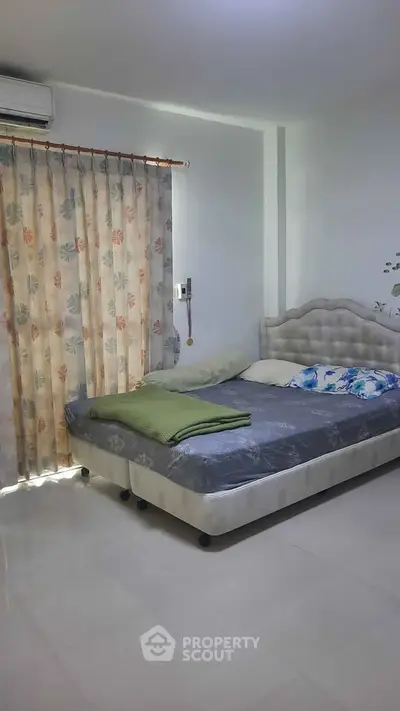 Cozy bedroom with elegant bed and floral curtains, perfect for relaxation.