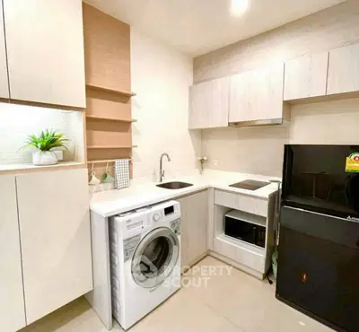 Modern kitchen with sleek cabinets, washing machine, and appliances