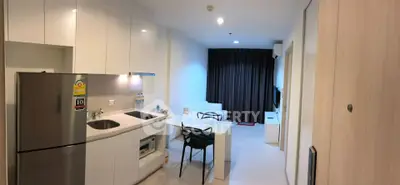 Modern kitchen and living area with sleek design and integrated appliances in a cozy apartment.