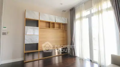 Modern living room with stylish wooden shelving and large windows for natural light.