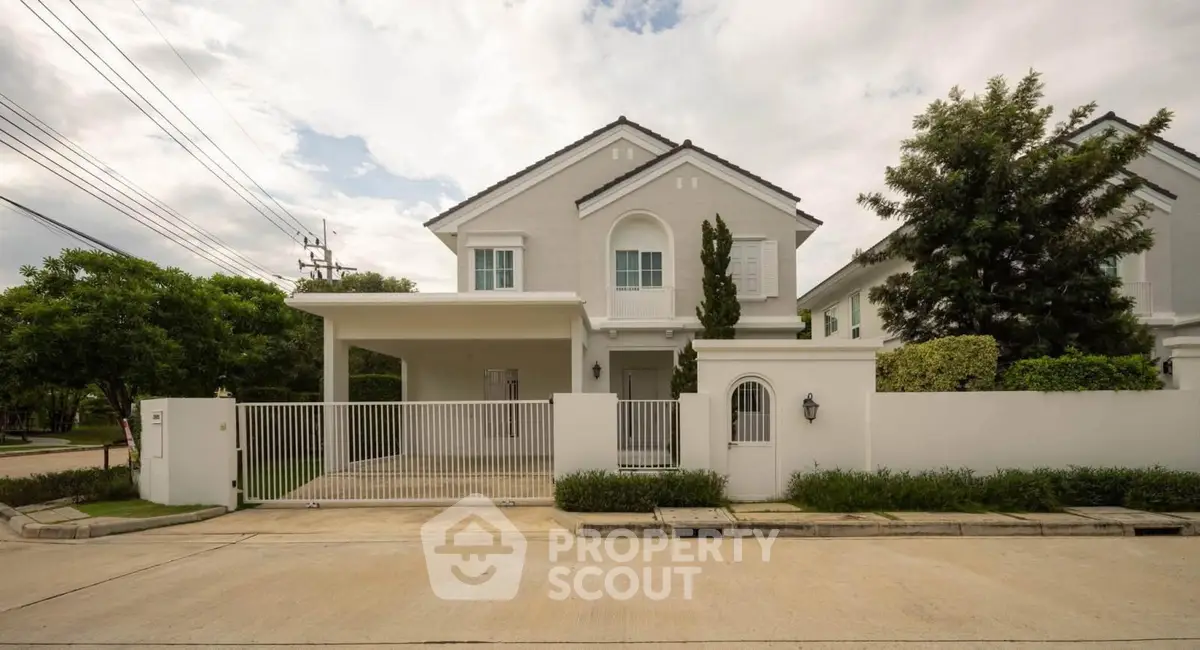 Charming suburban house with gated driveway and lush greenery, perfect for family living.