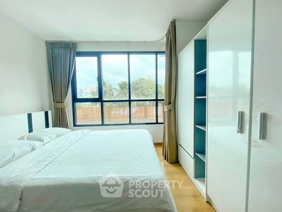 Bright and spacious bedroom with large windows and modern furnishings.