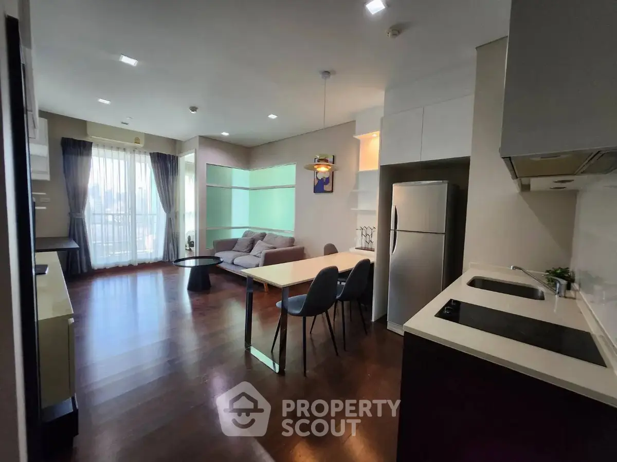 Modern open-layout living room and kitchen with sleek design and natural light.