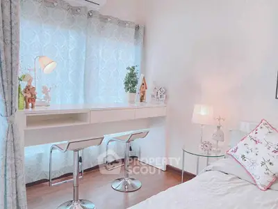 Charming bedroom with stylish decor and natural light, featuring a cozy study nook and elegant furnishings.
