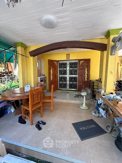 Charming entrance with wooden furniture and welcoming mat, perfect for a cozy home vibe.