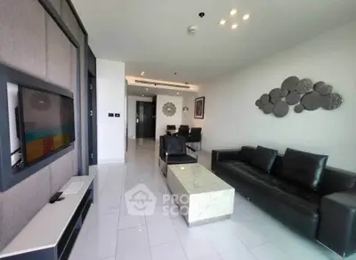 Modern living room with sleek black leather sofa and wall-mounted TV in a stylish apartment.