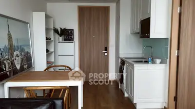 Modern kitchen with wooden dining table and sleek cabinetry in a cozy apartment setting.