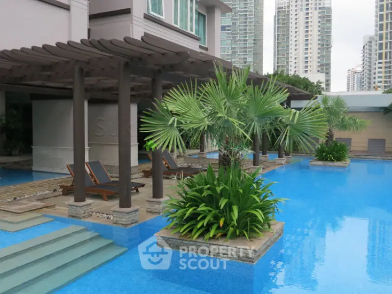 Luxurious apartment complex with stunning pool and lush greenery, perfect for relaxation and leisure.