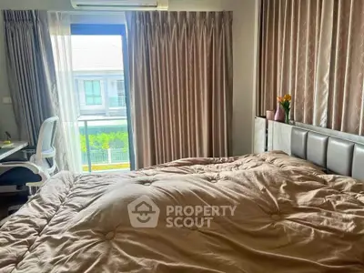 Cozy bedroom with plush bedding and natural light from large window