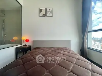 Modern bedroom with large window offering stunning city views and stylish decor.