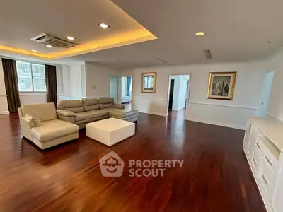 Spacious living room with elegant hardwood floors and modern furniture in a luxury apartment.