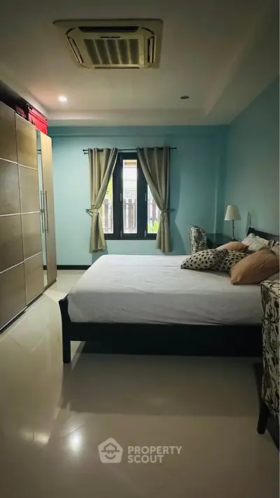 Spacious bedroom with modern decor and large wardrobe in a cozy home.