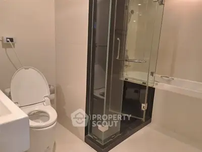 Modern bathroom with glass shower and sleek fixtures in a contemporary apartment.