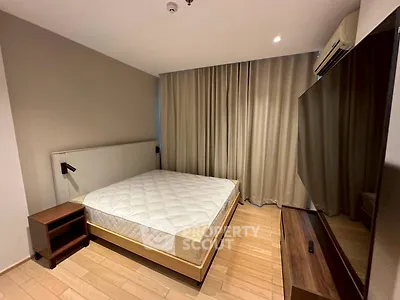 Modern bedroom with wooden flooring and large window curtains