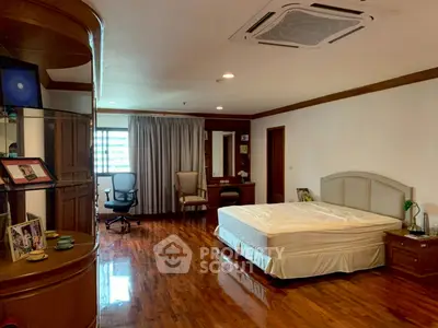 Spacious bedroom with wooden flooring and modern furnishings