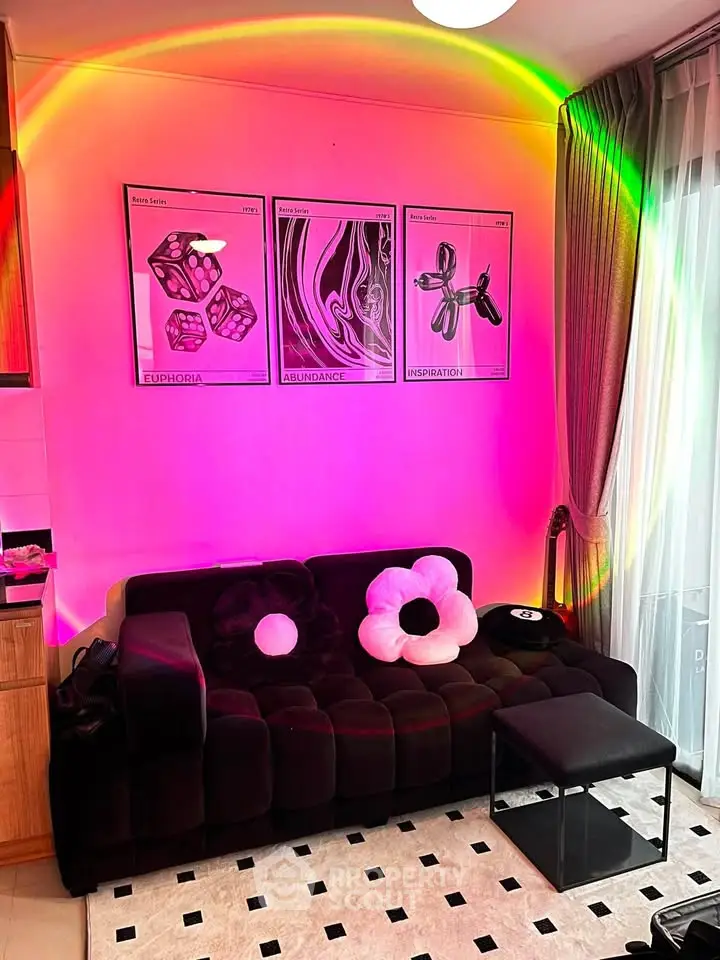 Stylish living room with modern decor and vibrant lighting, featuring a plush sofa and artistic wall posters.