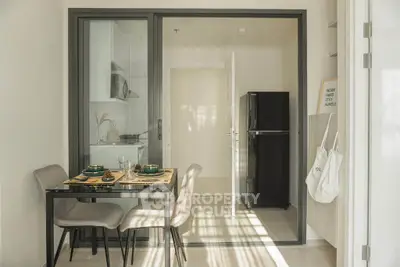 Modern kitchen with dining area and sleek black fridge in cozy apartment