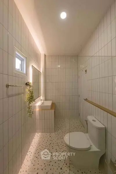 Modern bathroom with sleek design, featuring terrazzo flooring and stylish wall tiles.