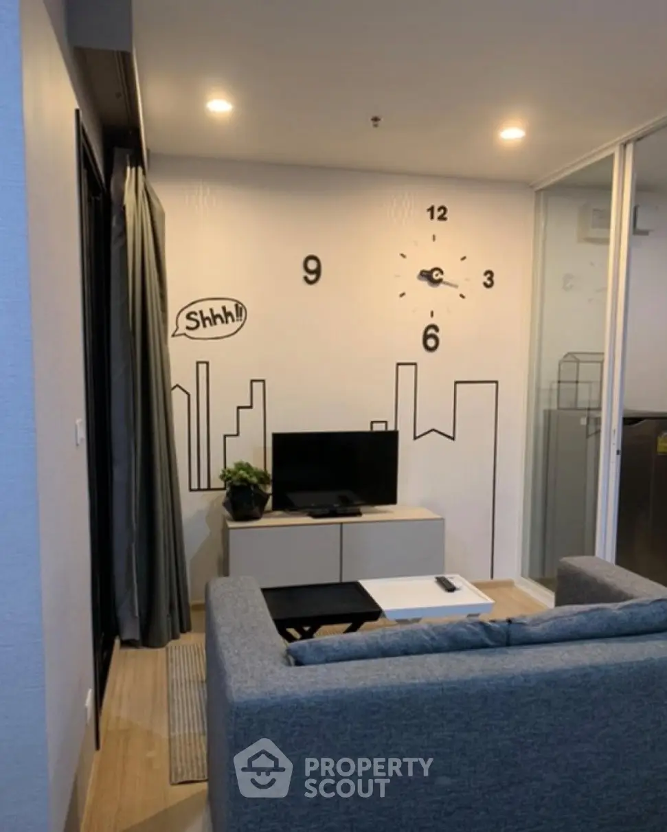 Modern living room with stylish wall clock and cozy seating area in a contemporary apartment.
