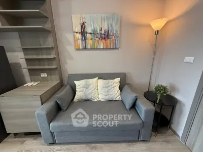 Cozy living room with modern gray sofa, abstract art, and stylish floor lamp.