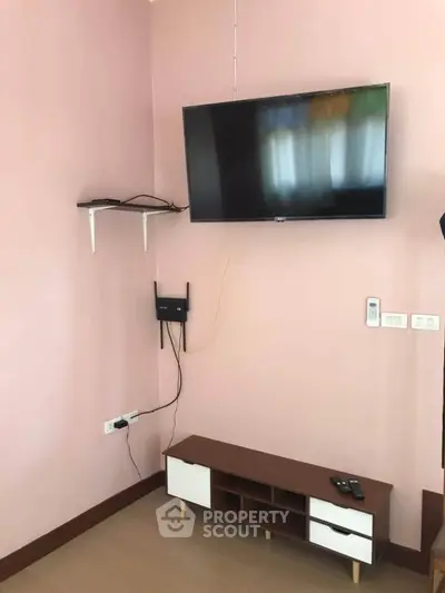 Modern living room with wall-mounted TV and sleek wooden cabinet