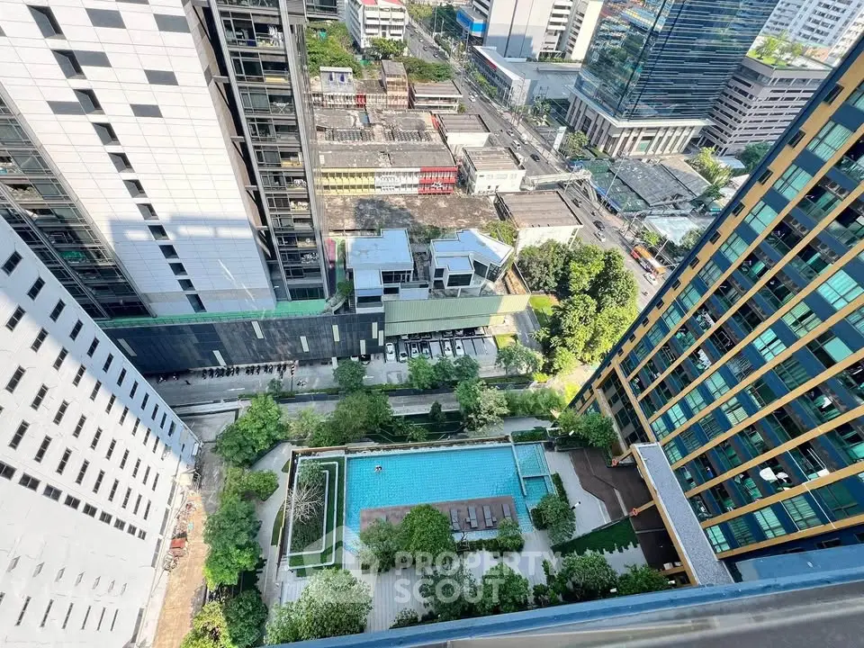 Stunning aerial view of modern urban apartment complex with pool and lush greenery.