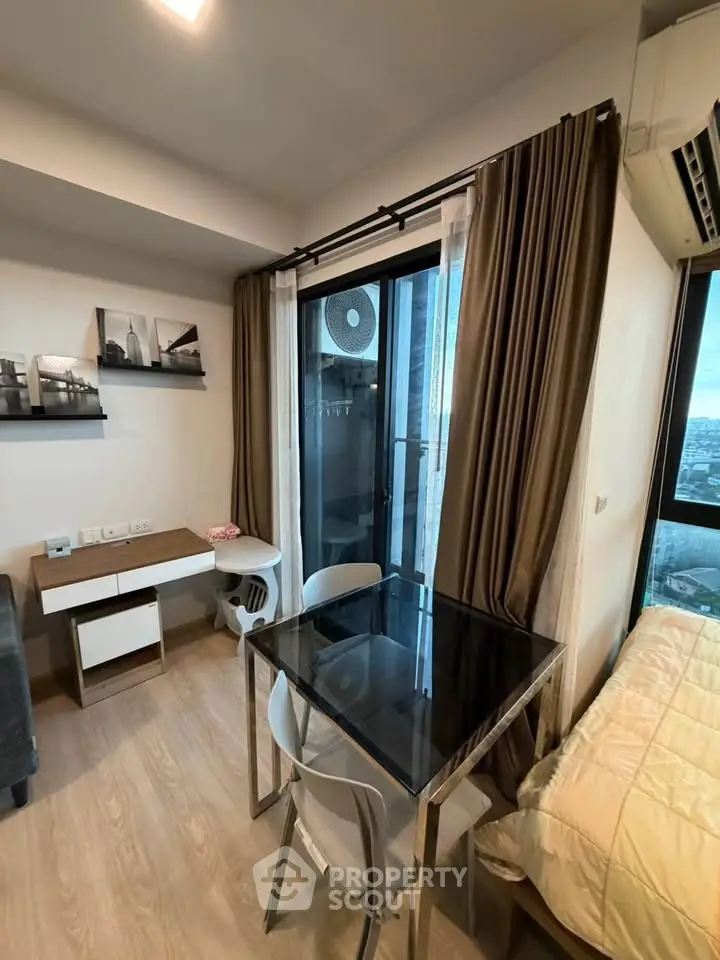 Modern compact living room with balcony view, stylish furniture, and natural light.