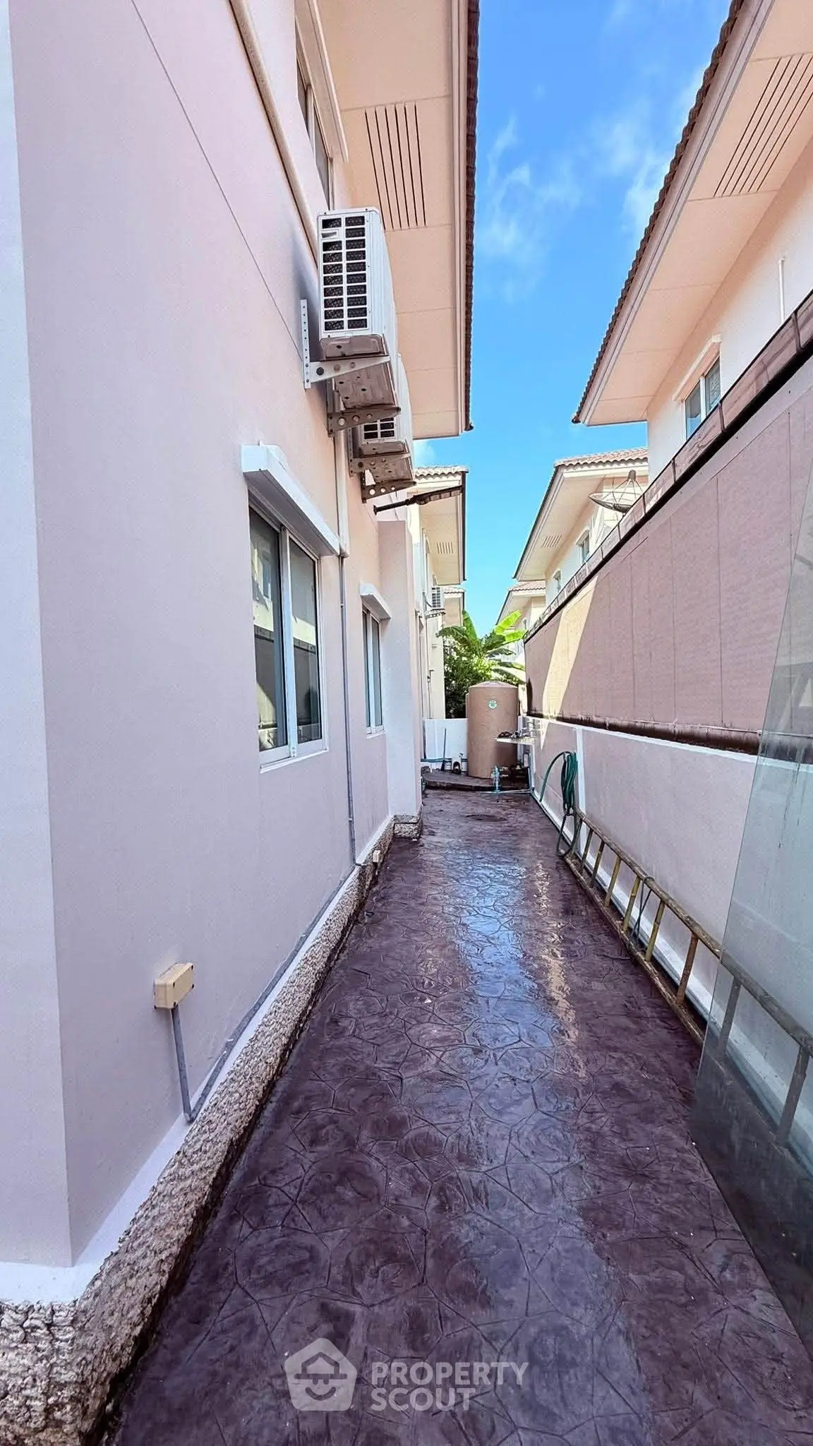Charming exterior view of a modern house with clean pathway and air conditioning unit.
