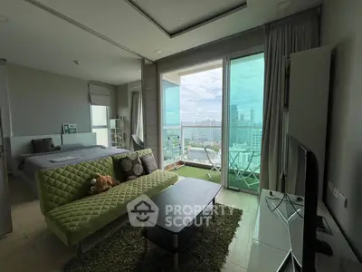 Modern living room with green sofa and city view balcony in high-rise apartment